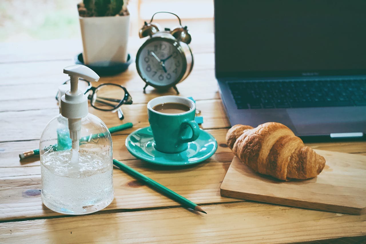 services-01 A rustic workspace featuring coffee, croissant, laptop, and essentials on a wooden table.